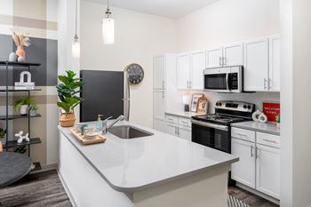 Shaker-style cabinetry with quartz countertops in kitchen and baths
